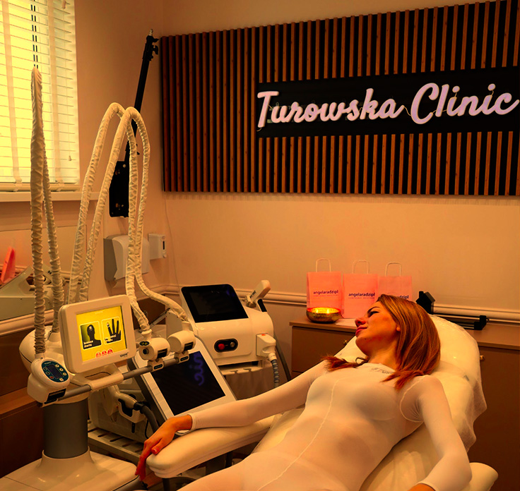 Kobieta odpoczywa na fotelu w klinice kosmetologii estetycznej, obok niej znajduje się sprzęt medyczny.